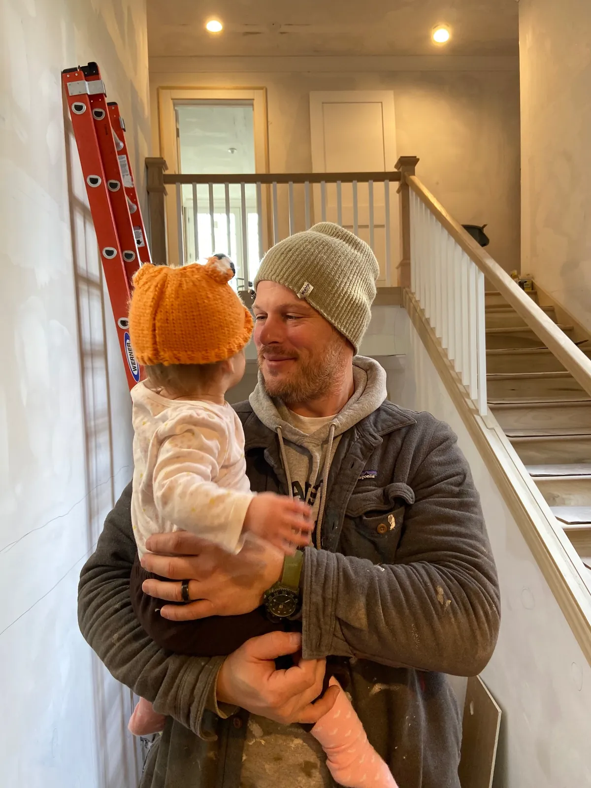 Carson Little holding his daughter Piper on a job site
