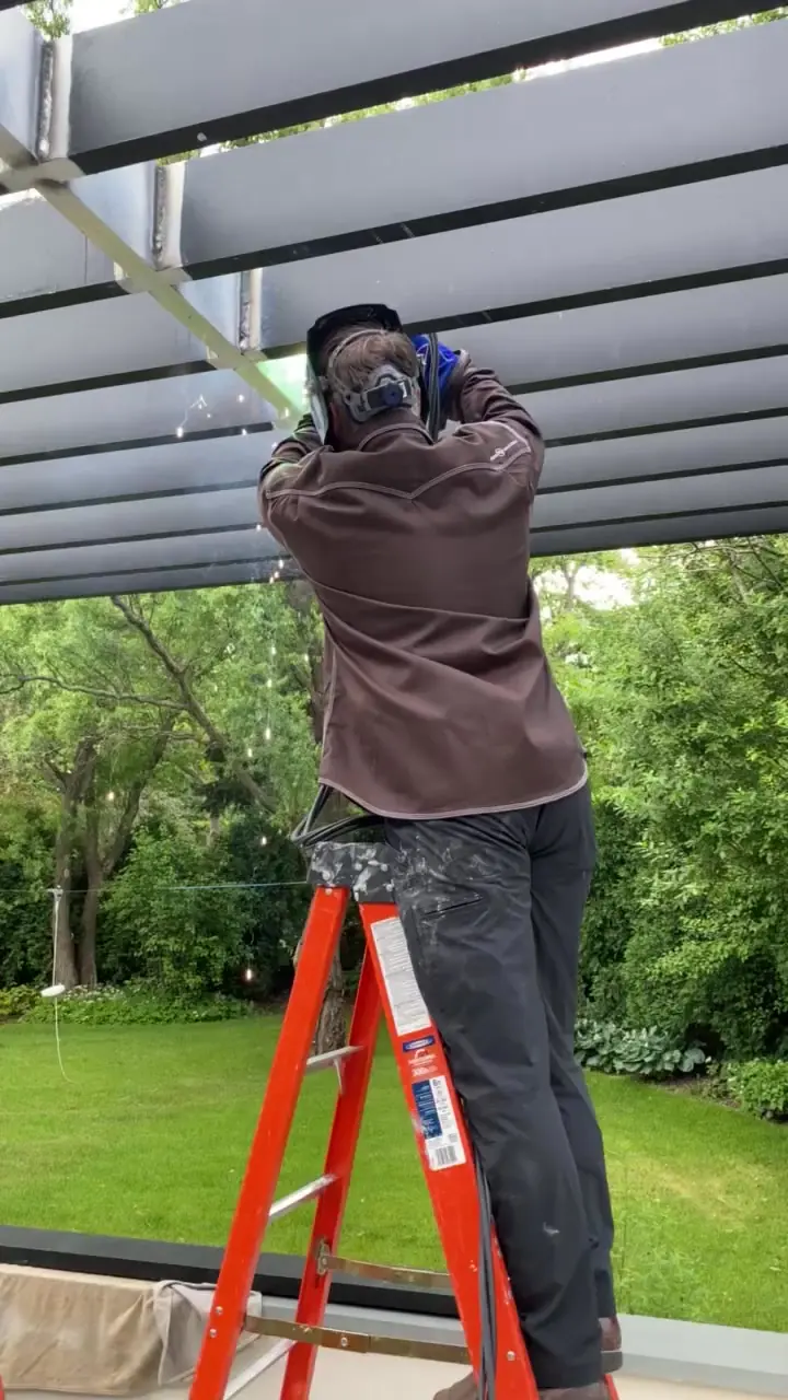 Anderson Little welder fabricating a steel pergola structure on site
